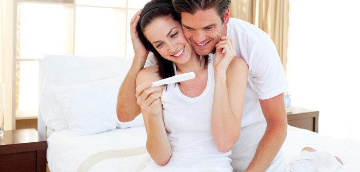 Paar freut sich über positiven Schwangerschaftstest.